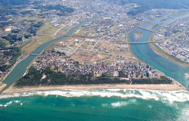 益田平野 ― 手前の日本海に、高津川（右）、益田川（左）が注ぐ。益田川河口の砂州の内側に中世の港町の遺跡（中須東原遺跡）がある。