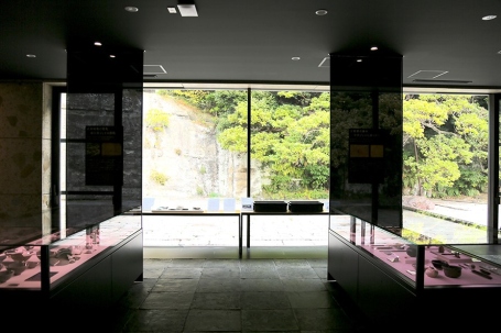 窓の外の庭園風景と調和する展示室の空間